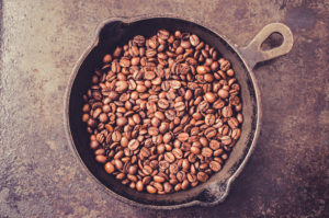 Frying pan with coffee beans during roasting