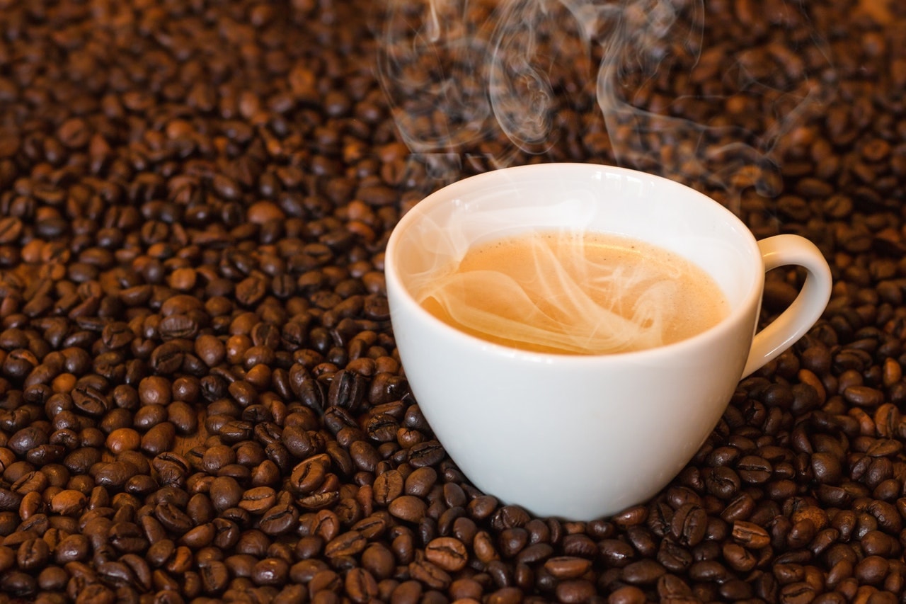 White coffee cup on top of beans