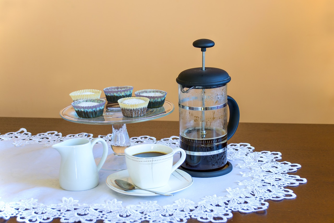 french press vs. aeropress on a table with cupcakes